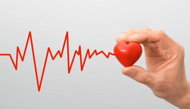Man,Holding,Small,Red,Heart,On,Light,Background,,Closeup
