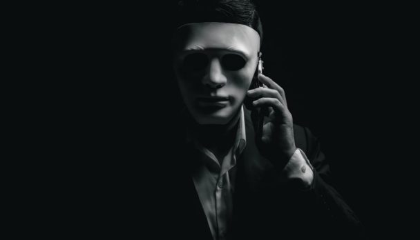 Unknown,Businessman,Wearing,Mask,With,Covered,Face,Using,Mobile,Phone