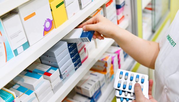 Pharmacist,Holding,Medicine,Box,And,Capsule,Pack,In,Pharmacy,Drugstore.